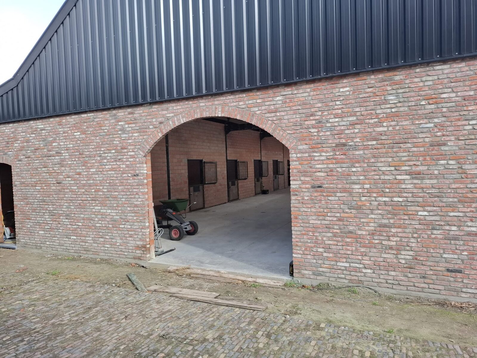 Doorgang met zicht op de stallen