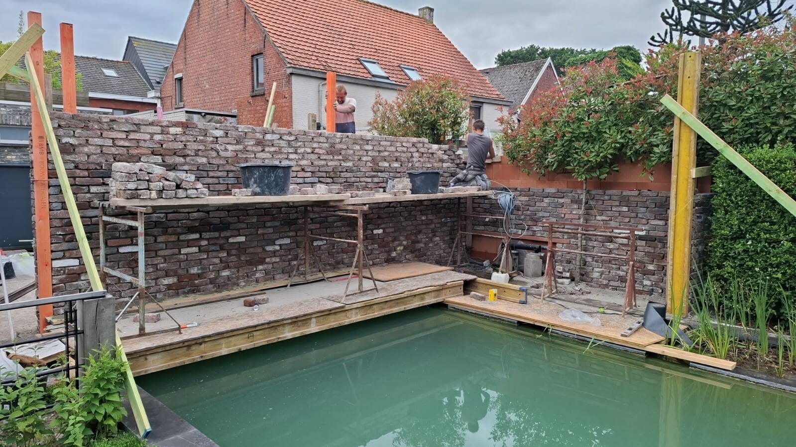 Afgewerkte muur langs de vijver